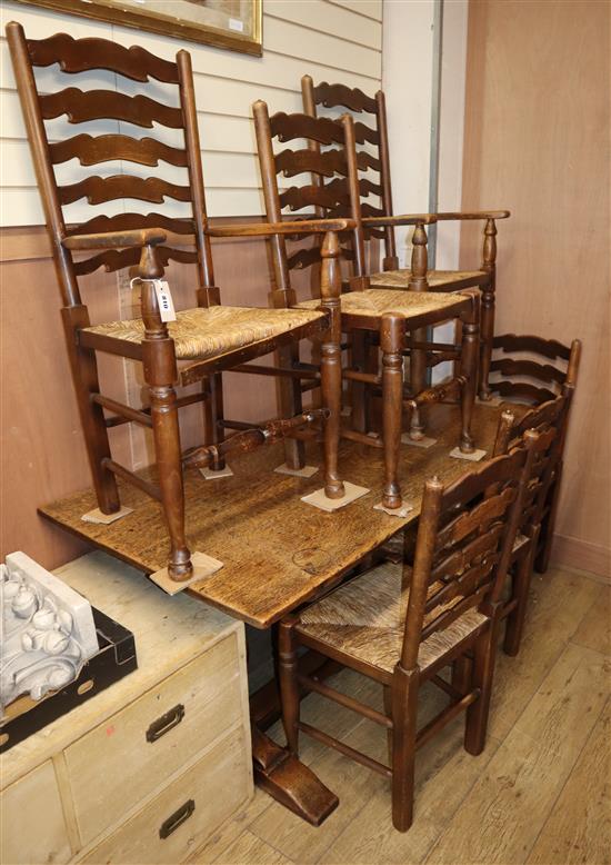 A 1920s oak refectory dining table and six rustic ladder back chairs, two with arms table length 152cm